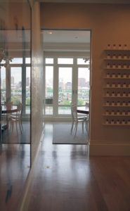 view of the gallery to the dining room in an art collector's apartment at the Mandarin Oriental in Boston, designed by Steven Elmets Architecture