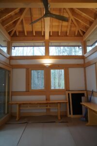 Interior of an exercise pavilion with high ceilings and wood beams designed by Steven Elmets Architecture